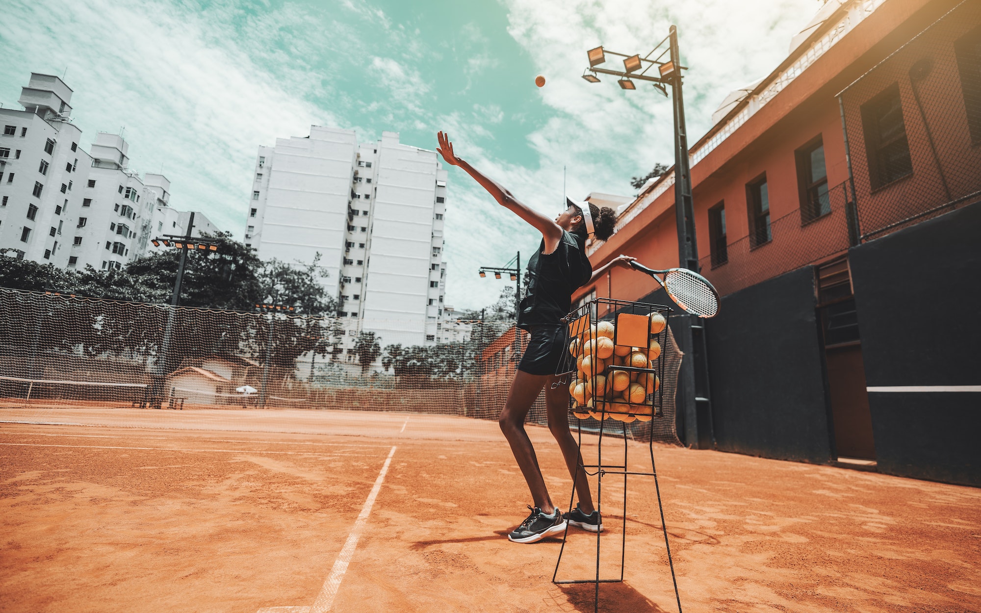 Black girl playing tennis on a court